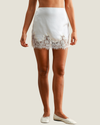 Ella white satin mini skirt featuring delicate lace trim along the hem.