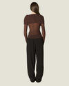 Everleigh Sheer Mesh Top featuring a body-skimming silhouette, long sleeves, draped shoulder overlay, and ruched detailing.