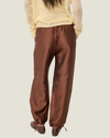 Women's taffeta drawstring pants with a relaxed fit, adjustable waist, tie-leg detailing, and patch pockets.