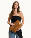 Angela tan vegan leather envelope crossbody bag with gold-tone hardware, detachable chain strap, and magnetic closure.