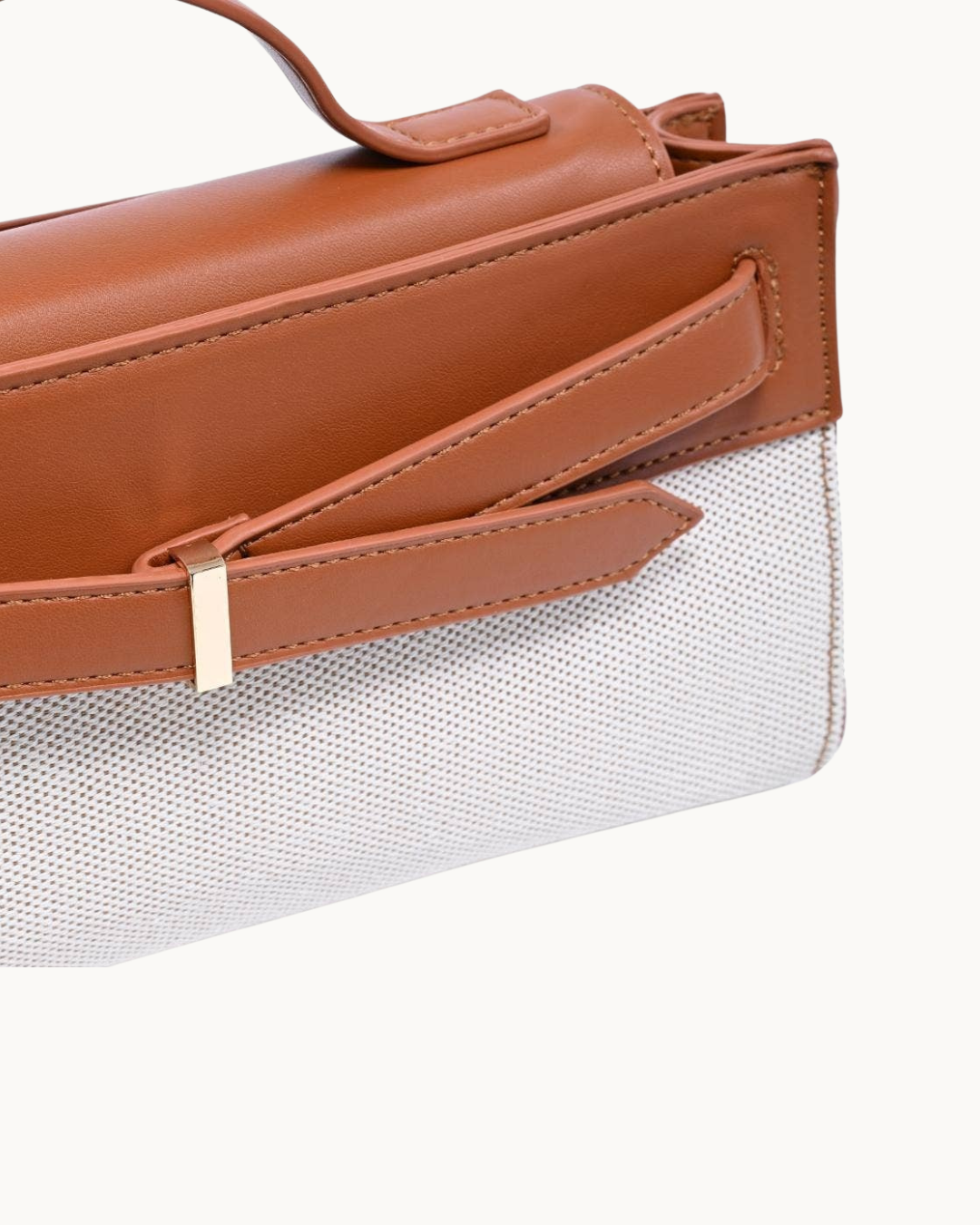 Tan and ivory vegan leather top-handle clutch. 